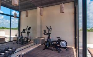 a gym with three treadmills and exercise bikes at Naj Kiin- Aldea Zama Tulum by Casago in Tulum