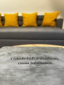 a sign on a couch in front of a couch at City-Designapartment in Gaggenau