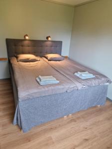 un letto in una stanza con due asciugamani di Lantlig villa utanför Uppsala ad Alunda