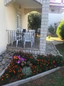 a porch with a table and chairs and flowers at Apartments Marinela in Poreč