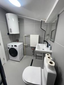 La petite salle de bains est pourvue de toilettes et d'un lavabo. dans l'établissement King Size Apartment, à Skopje