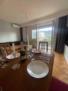 a dining room table with a bottle of wine and glasses at King Size Apartment in Skopje