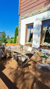 a patio with a table and chairs on a wooden deck at Goralove Pole in Brzegi