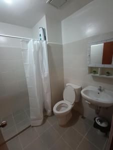 a white bathroom with a toilet and a sink at 3 J's STAYCATION in Bacolod