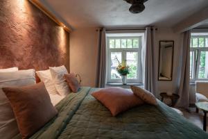 een slaapkamer met een groot bed en 2 ramen bij Le Poirier de la Canette in Durbuy