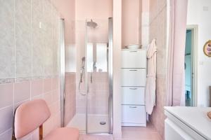 ein rosafarbenes Bad mit einer Dusche und einem rosa Stuhl in der Unterkunft Ca' Muna - Sea View Penthouse, Private Rooftop, Walking to the Beach in Rapallo