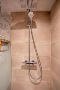 een douche met een douchekop in de badkamer bij Le Poirier de la Canette in Durbuy