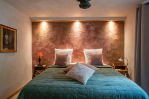 a bedroom with a green bed with a red wall at Le Poirier de la Canette in Durbuy +15 photos