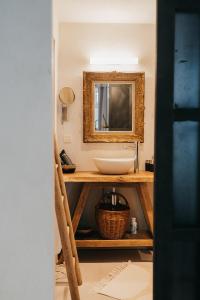 een badkamer met een wastafel en een spiegel bij Le Poirier de la Canette in Durbuy