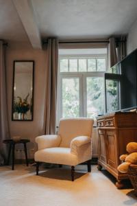 een woonkamer met een stoel en een raam bij Le Poirier de la Canette in Durbuy