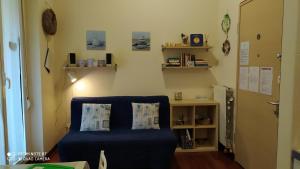 ミラノにあるZara Cosy & Cheap Apt - Easy parkingの青い椅子と本棚付きの部屋