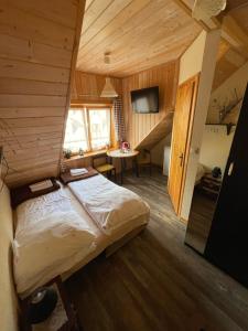 a bedroom with a bed in a room with wooden walls at Jasminowe Wzgorze in Wilkanów