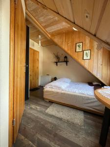 a bed in a room with wooden walls at Jasminowe Wzgorze in Wilkanów