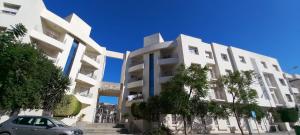 a car parked in front of a white building at Confort Inn Lac 2 in Tunis