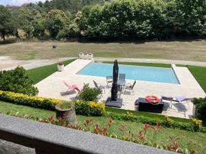 una piscina en un patio con sillas y una piscina en Quinta Escondida da Avessadas, 