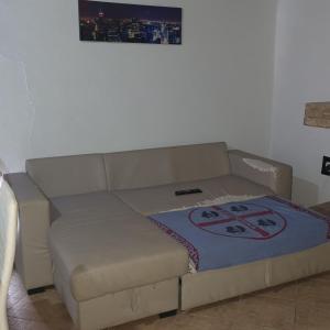 um sofá numa sala de estar com um cobertor em b e b bascus argius em Cagliari