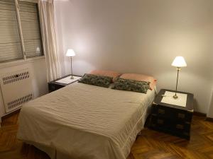 1 dormitorio con 1 cama con 2 mesitas de noche y 2 lámparas en Departamento en Recoleta en Buenos Aires