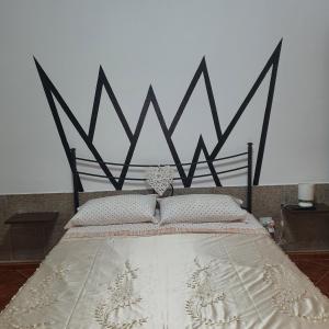 a bedroom with a bed with a black and white headboard at b e b bascus argius in Cagliari