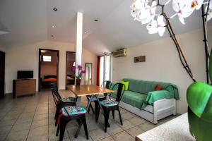 a living room with a couch and a table and chairs at GOLDEN SUN STUDIOS in Kallithea Halkidikis