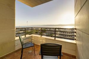 a balcony with two chairs and a view of the ocean at Luciana Hotel by Bratus in Aqaba