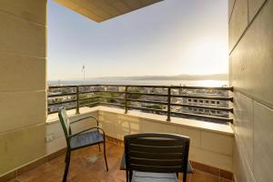 a balcony with two chairs and a view of the ocean at Luciana Hotel by BRATUS in Aqaba