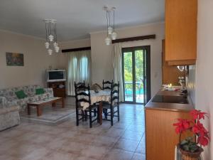 Val's place في ميتيليني: مطبخ وغرفة معيشة مع طاولة وكراسي