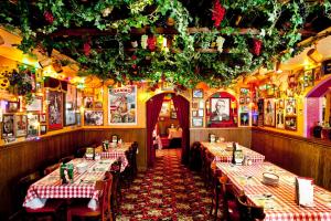 a restaurant with tables with red and white tablecloths at Beddable Unit by The Excalibur Casino Las Vegas STRIP in Las Vegas