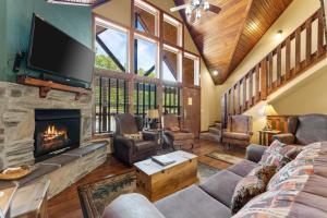a living room with a fireplace and a tv at Makin Memories Lodge Cabin in Branson West