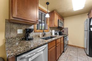 a kitchen with wooden cabinets and a counter top at Makin Memories Lodge Cabin in Branson West