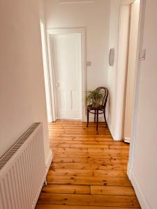 a hallway with a chair and a wooden floor at Gorgie Nook in Edinburgh