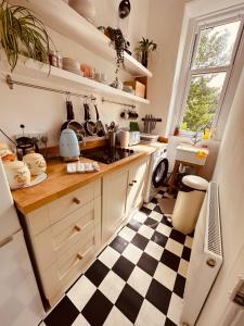 a kitchen with a black and white checkered floor at Gorgie Nook in Edinburgh