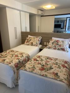 a room with two beds with flowers on them at Dunas de Cotovelo in Parnamirim