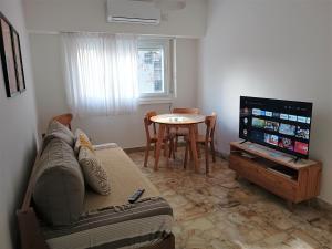 a living room with a couch and a tv and a table at Hermoso departamento en el corazón de Palermo Soho in Buenos Aires
