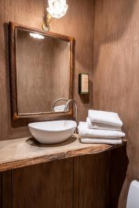 La salle de bains est pourvue d'un lavabo, d'un miroir et de serviettes. dans l'établissement La Petite Ruelle, à Durbuy