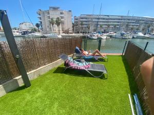 a couple of people laying in lawn chairs on a water slide at Apartamento puerto madeira Roses in Roses