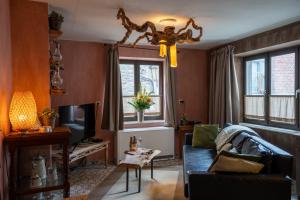 a living room with a couch and a television at La Petite Ruelle in Durbuy