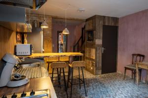 una cucina con bancone e alcuni sgabelli in una stanza di La Petite Ruelle a Durbuy
