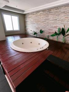 a large bath tub sitting on a wooden floor at Apartamento de frente para o Mar in Vitória