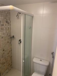 a bathroom with a toilet and a glass shower at Dunas de Cotovelo in Parnamirim