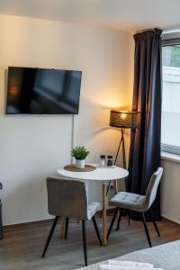 a living room with a table and chairs and a lamp at Studio Apartment am Kurpark in Bad Segeberg