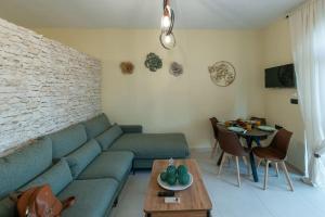 a living room with a blue couch and a table at Perion stone apartment near to the sea No1 in Kolymvari