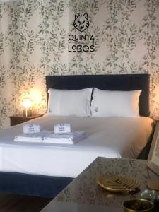 a bedroom with a bed with two towels on it at Quinta dos Lobos Boutique Hotel - Nature Experience in Sintra