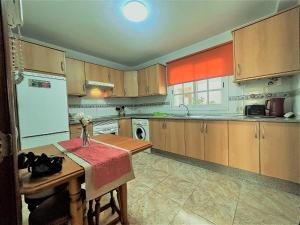 a kitchen with a table and a white refrigerator at Alquilaencanarias Llano del Camello in San Miguel de Abona