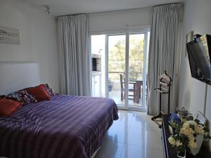 una camera da letto con un letto e una porta scorrevole in vetro di Green Park penthouse 2 dormitorios a Punta del Este Altre 32 foto