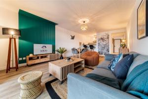 a living room with a blue couch and a table at Appartement spacieux avec vue in Le Tampon