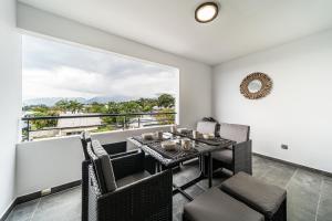 a dining room with a table and chairs and a large window at Appartement spacieux avec vue in Le Tampon