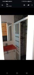 a bathroom with a red sink and a mirror at Chalet adosado con jardín in Cebreros