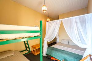 a bedroom with two bunk beds with white curtains at Abaré floating Lodge in Manaus
