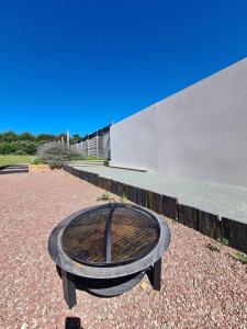 uma mesa de madeira em frente a um edifício em L'Ouvéa joli gîte à 10 min du parc le Puy du Fou em Sevremont