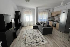 a living room with a couch and a kitchen at Alex 3 Apartament in Iaşi +10 photos